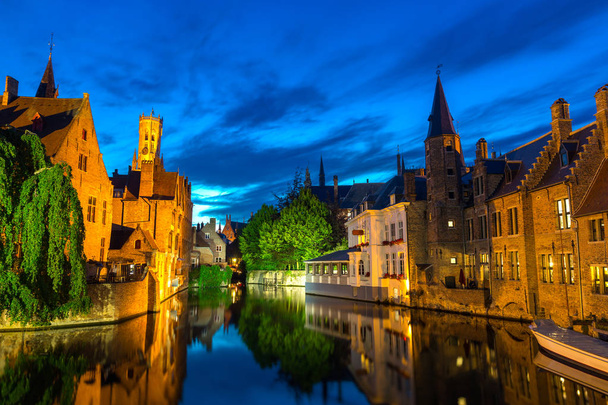 ベルギー、ブリッジ、川、夜景、ガラスの水の表面に石造りの建物と古代ヨーロッパの町。観光と旅行、有名なヨーロッパのランドマーク、人気のある場所、西フランダース - 写真・画像