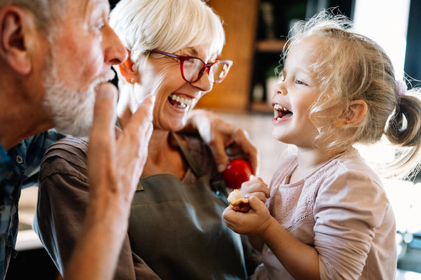 Happy smiling grandparents having fun times with children at home - 写真・画像