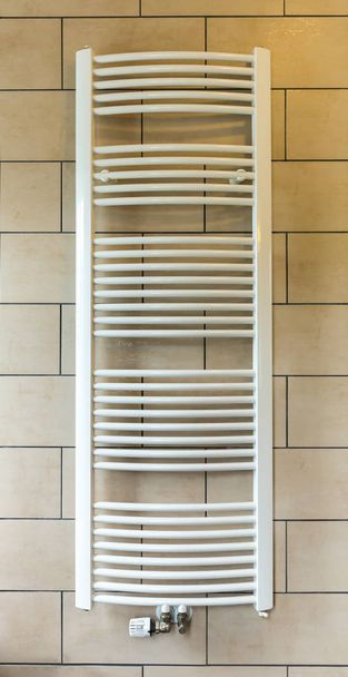 Heated towel rail in hotel bathroom closeup, Europe tourism. European motel furniture for personal hygiene, apartment for comfortable leisure, nobody - Photo, Image