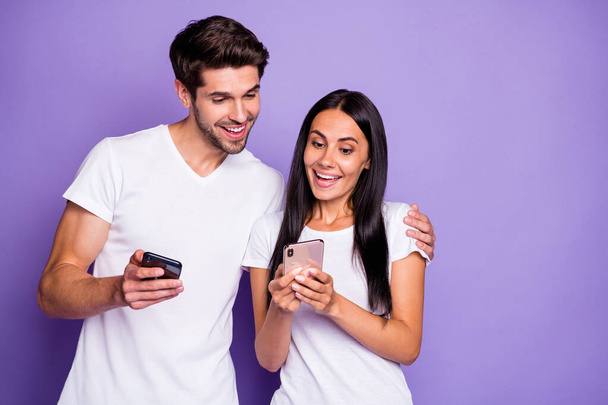 Close-up portrait of his he her she nice attractive lovely cheerful cheery glad amazed couple using digital device watching media content isolated on purple violet lilac color pastel background - Photo, image