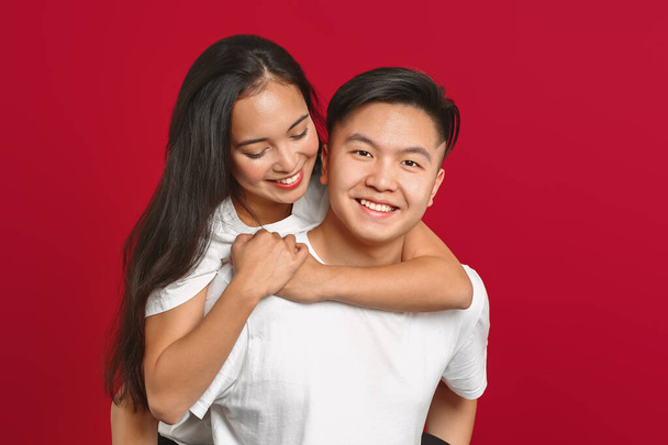 Porträt eines glücklichen jungen asiatischen Paares auf farbigem Hintergrund - Foto, Bild