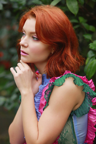 bela menina ruiva em arranjador onde azálea floresce em um vestido de voo colorido
 - Foto, Imagem