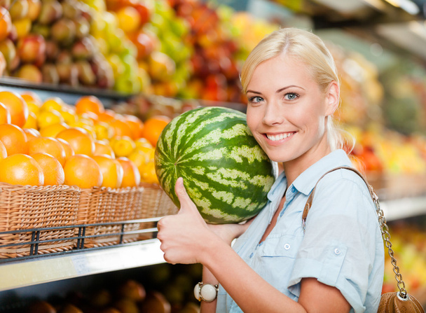 Girl at the store choosing fruits hands watermelon - 写真・画像