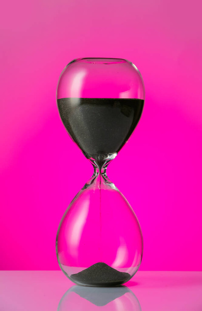 Reloj de arena de cristal sobre fondo de color
 - Foto, Imagen