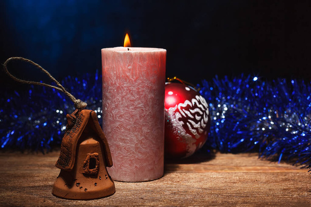 Feestelijke kerstachtergrond: kaars branden, Nieuwjaarsspeelgoed en knutselen - Foto, afbeelding
