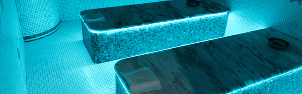 panoramic shot of hammam tables with blue lights in spa salon  - Photo, Image