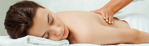 панорамный снимок массажиста, делающего массаж спины привлекательной женщине в спа
  - Фото, изображение