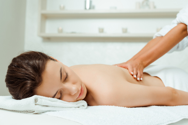 cropped view of masseur doing back massage to attractive woman in spa  - Φωτογραφία, εικόνα