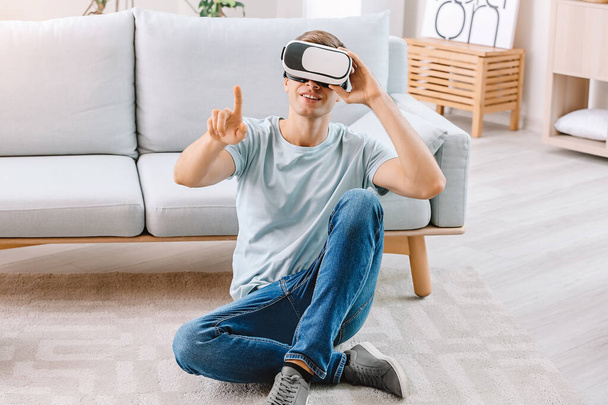 Молодой человек в очках виртуальной реальности дома - Фото, изображение