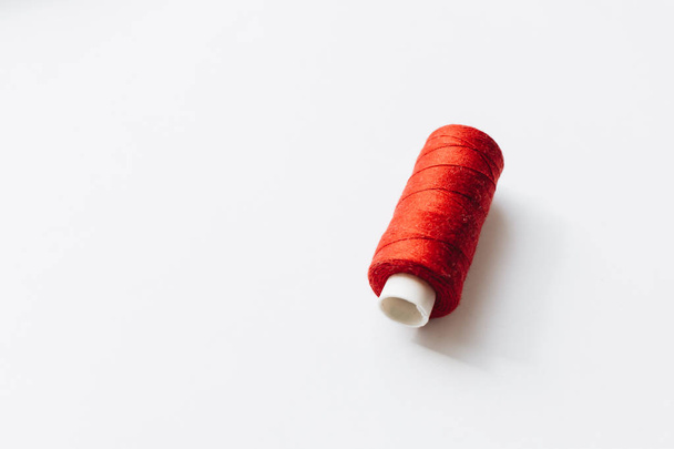 red sewing thread on background  - 写真・画像