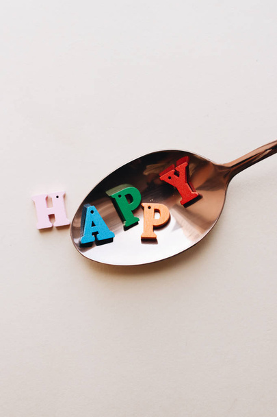 πολύχρωμα ξύλινα γράμματα σε κουτάλι, HAPPY γράμματα  - Φωτογραφία, εικόνα