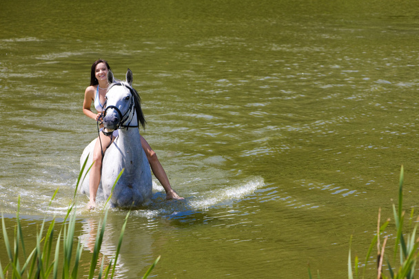 Equestrian on horseback riding through water - Photo, Image