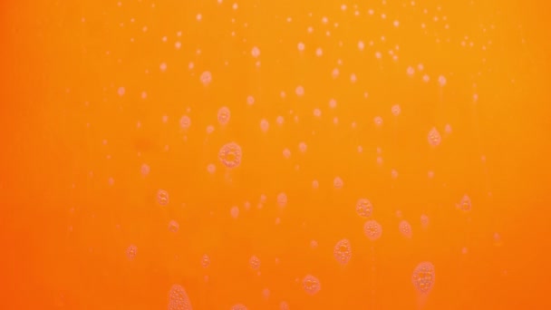 Burbujas de espuma de jabón que fluyen sobre fondo naranja
. - Metraje, vídeo