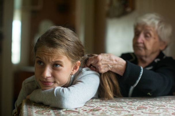Velha avó mulher tranças uma menina da neta cabelo longo
.  - Foto, Imagem