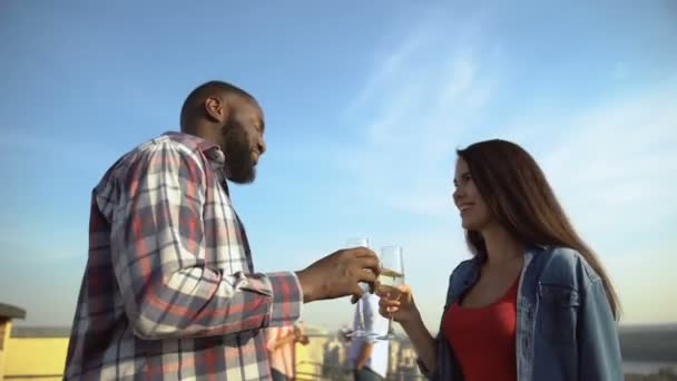 Joven pareja multiétnica bebiendo champán y conociéndose en la fiesta en el techo
 - Imágenes, Vídeo