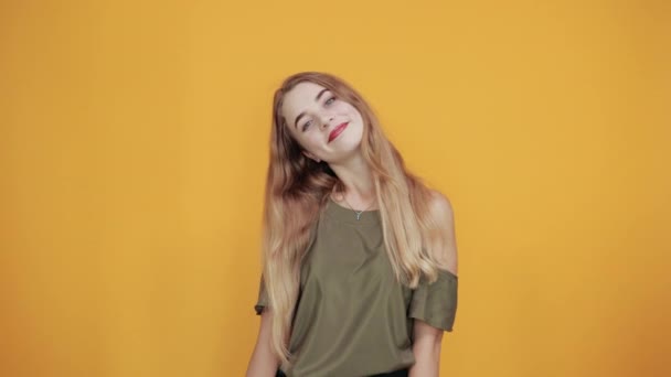 Jeune femme blonde faisant geste gagnant gardant les pouces sous le menton
 - Séquence, vidéo