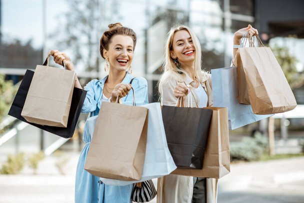 Mujeres con bolsas de compras cerca del centro comercial al aire libre
 - Foto, imagen