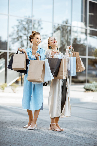 Γυναίκες με τσάντες ψώνια κοντά στο εμπορικό κέντρο σε εξωτερικούς χώρους - Φωτογραφία, εικόνα