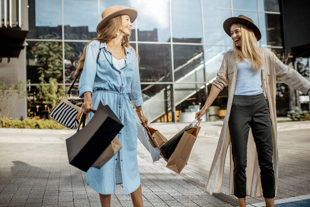 Femmes avec sacs à provisions près du centre commercial à l'extérieur
 - Photo, image