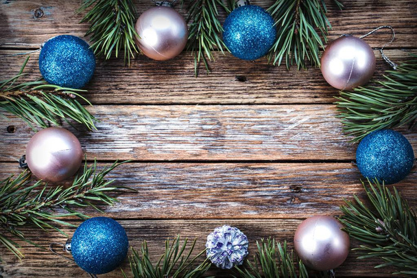 Bolas de Natal e ramos de pinho dispostos em um círculo em um fundo de madeira. Conceito de férias de inverno. Vista de cima. Espaço de cópia
 - Foto, Imagem