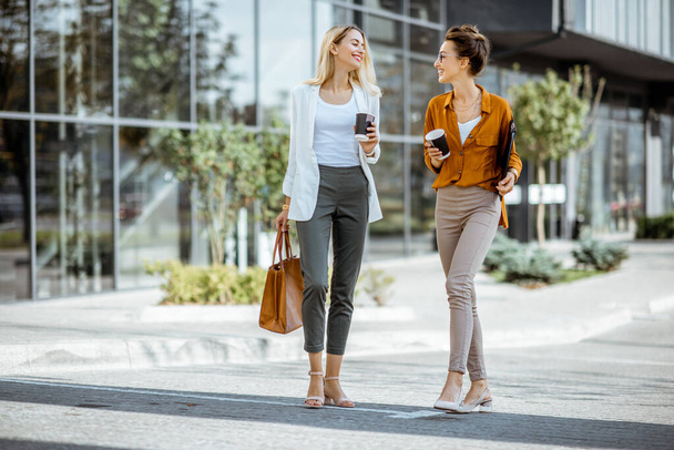 Two businesswomen walking outdoors - Φωτογραφία, εικόνα