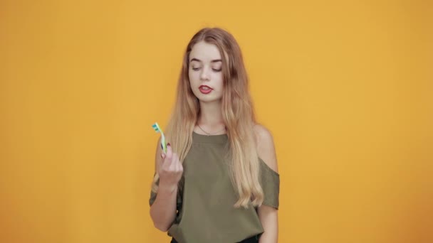 Beautiful caucasian young person keeping toothbrush, smiling, holdint thumb up - Footage, Video
