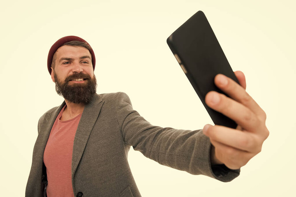 His best selfie is yet to come. Bearded man smiling to selfie camera. Happy hipster taking selfie with smartphone in hand. Perfect selfie from any angle - Zdjęcie, obraz