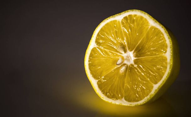 Yellow lemon on a dark background. - Zdjęcie, obraz