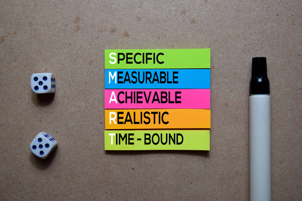 Smart - Specific, Measurable, Achievable, Realistic, and Time-Bound napisz na lepkiej nucie. Izolowane na drewnianym stole - Zdjęcie, obraz
