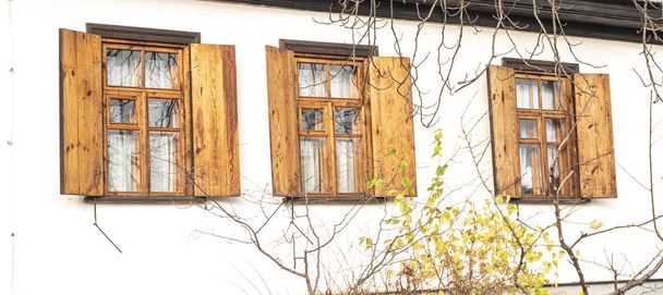 Ventanas con persianas de madera en una pared blanca
. - Foto, Imagen