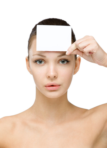 Menina nua mantém cartão copyspace na frente de sua testa
 - Foto, Imagem
