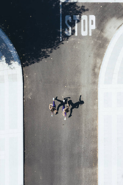 Two women running in the street - Фото, изображение
