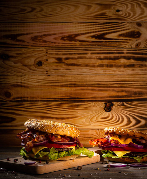 Bekon burger z patty wołowiny na drewnianym stole - Zdjęcie, obraz