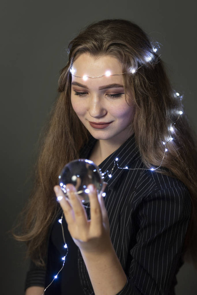  Retrato de una joven con una bola de cristal mágica. Ella se pregunta, dice la fortuna, en busca de amor
. - Foto, imagen