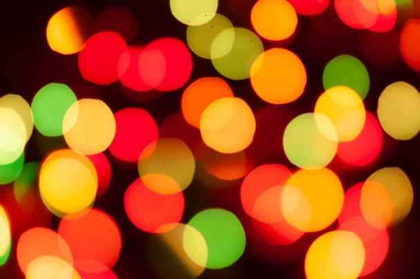glowing defocused colorful christmas lights on dark background - Photo, image