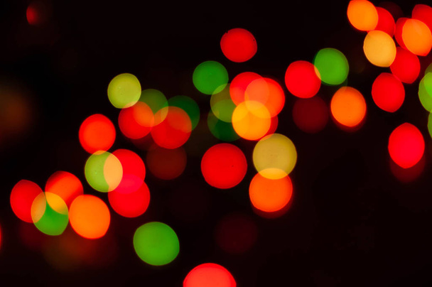 unfocused glowing shiny colorful lights bokeh with blurred dark background for wallpaper and design - Фото, изображение