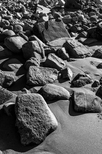 Αμμοσκεπής βράχος στην παραλία. Ασπρόμαυρη φωτογραφία - Φωτογραφία, εικόνα