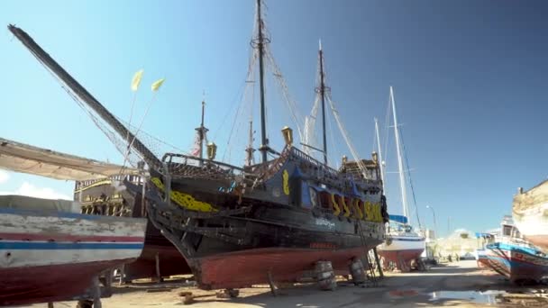 A pirate ship is under restoration. An old black ship stands on land. - Footage, Video