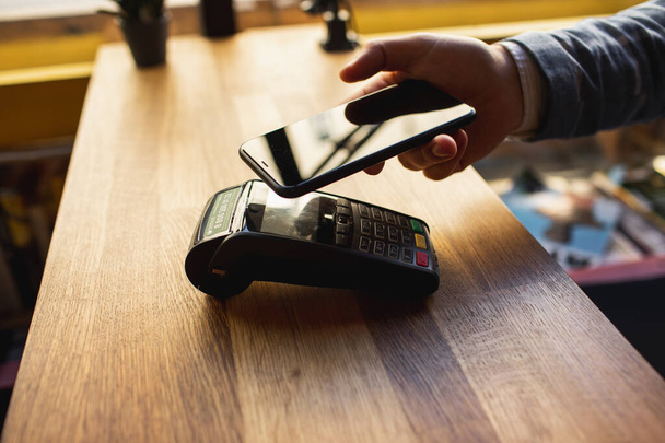 Contactless payment with your smartphone. Paying with a smartphone device on a credit card terminal. Wireless payment. - Fotoğraf, Görsel