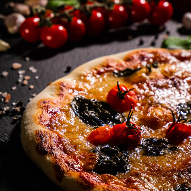 Traditionelle italienische Pizza, Gemüse, Zutaten auf dunklem Hintergrund. Pizza kocht im Ofen. Pizza-Menü. - Foto, Bild