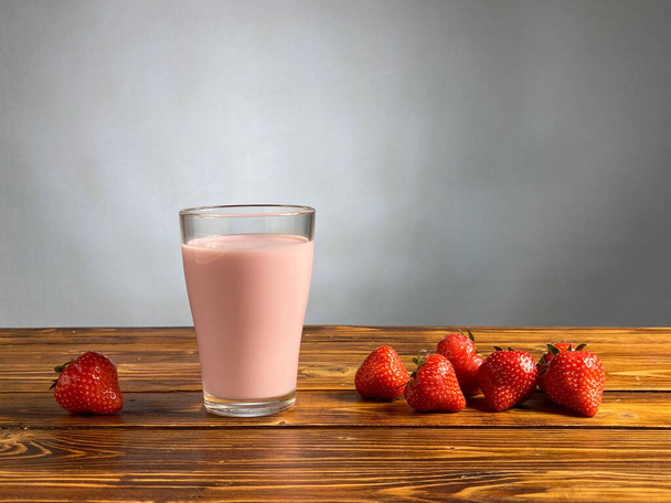 Yaourt aux fraises ou smoothie en verre sur table en bois
 - Photo, image