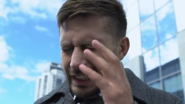 Tired business man having sharp pain attack outdoors, headache caused by stress - Video