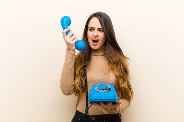 young pretty woman with a blue vintage phone - Fotoğraf, Görsel