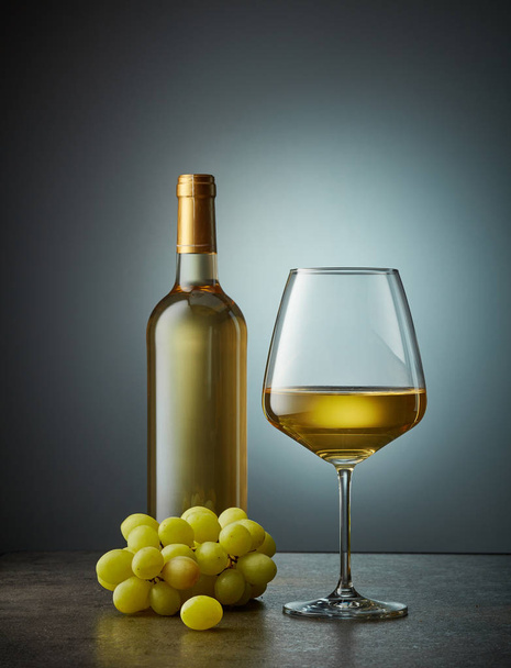ガラスと白ワインのボトル - 写真・画像
