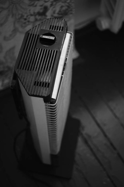 Calentador eléctrico retro Ugolek en la habitación, bw foto
. - Foto, imagen