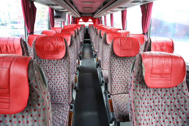az új modern busz belseje. buszbiztonsági övek. Ülések a busz belsejében, szállítás és kényelmes utazás. Nyitott dupla belső új, modern piros székek busz . - Fotó, kép
