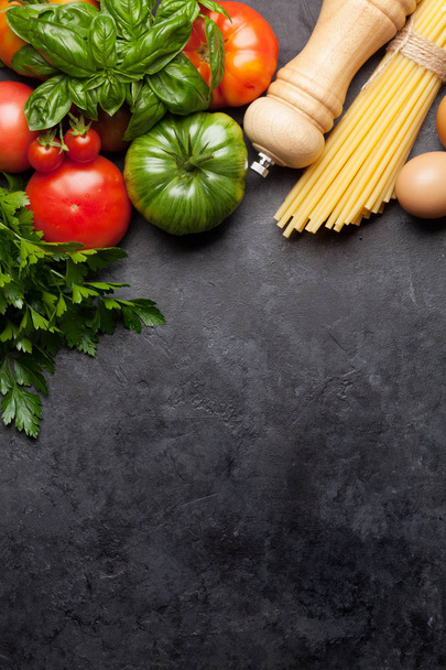 Pasta, tomaten en kruiden. Koken ingrediënten op stenen tafel. Bovenste weergave met Kopieer ruimte. Platte lay - Foto, afbeelding