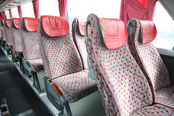 Innenraum des neuen modernen Busses. Sicherheitsgurte im Bus. Sitzgelegenheiten im Innenraum des Busses, Transport und komfortables Reisen. offener doppelter Innenraum neuer moderner roter Stühle . - Foto, Bild