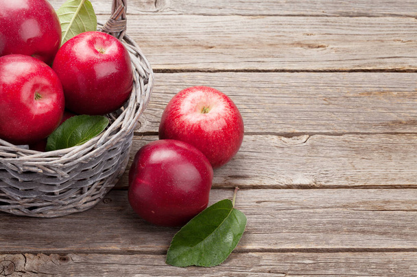 Dojrzałe czerwone jabłka w koszyku. Na drewnianym stole. Z przestrzenią do kopiowania - Zdjęcie, obraz