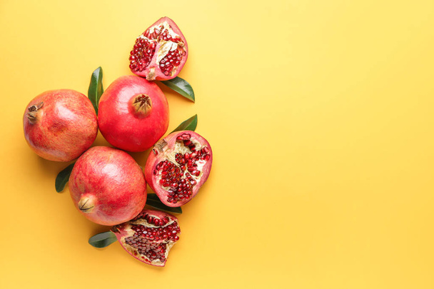 Ripe juicy pomegranates on color background - Foto, Imagen